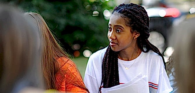 A young woman with a sheaf of papers