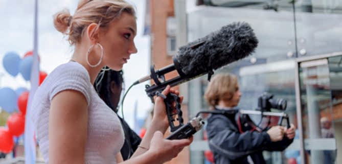 A young woman with sound recording equipment on a documentary making assignment