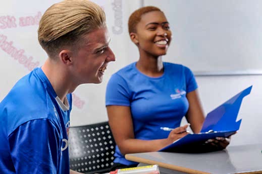 Two students in sports clothes laughing together 