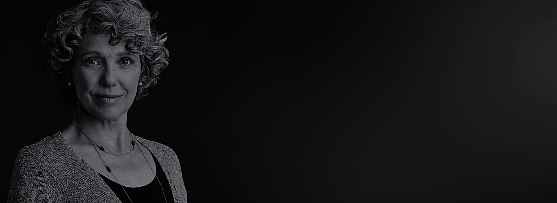 A young man with a determined expression looks out from deep shadow