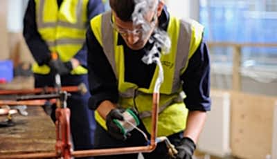 Student welding a pipe